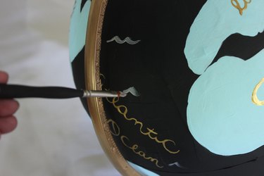 Add waves to the oceans with light gray paint.