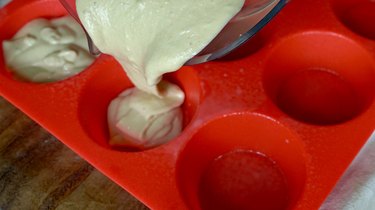 Pouring batter into muffin cups for peanut butter banana blender muffins