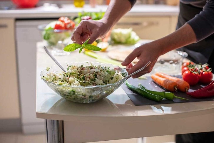 Man's Hands put a Mint on Salad