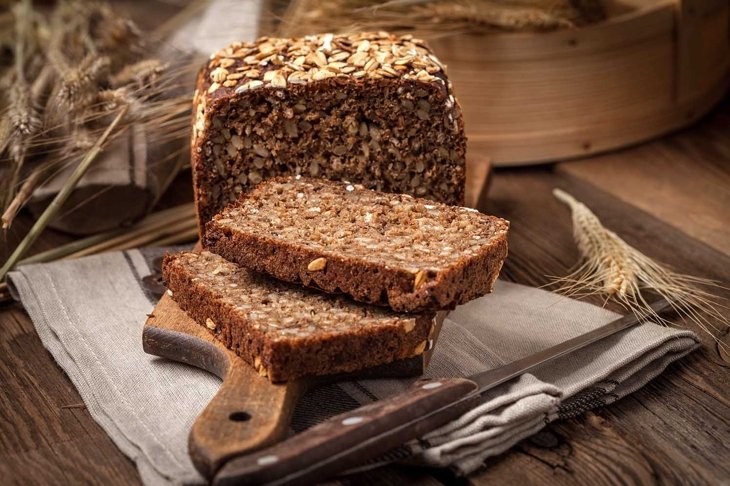 Whole Grain rye bread with seeds on a wooden board.