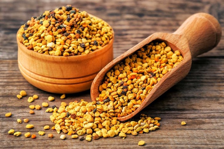healthy bee pollen grains on wooden background